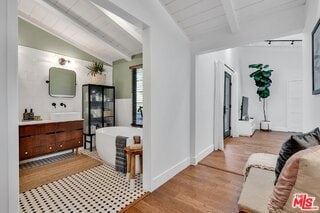 interior space featuring light hardwood / wood-style flooring, lofted ceiling with beams, and wooden ceiling