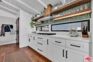 bar featuring lofted ceiling with beams, white cabinets, dark hardwood / wood-style flooring, and gas cooktop