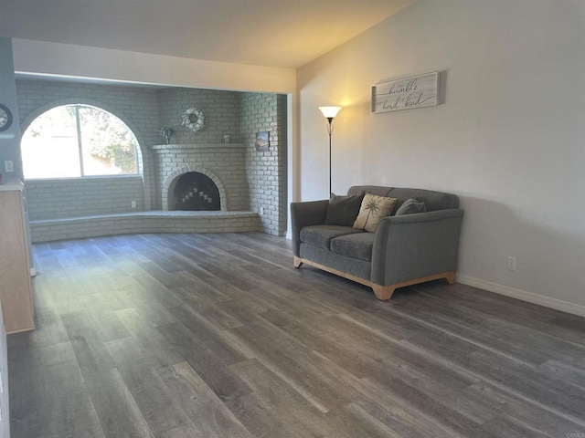 living room with dark hardwood / wood-style flooring, lofted ceiling, and a fireplace