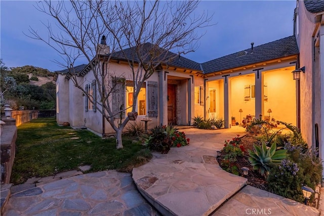 rear view of house featuring a yard and a patio area