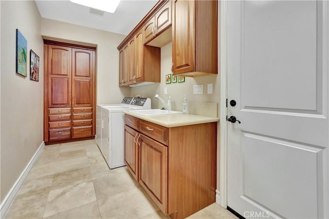 clothes washing area with sink, cabinets, and washing machine and clothes dryer