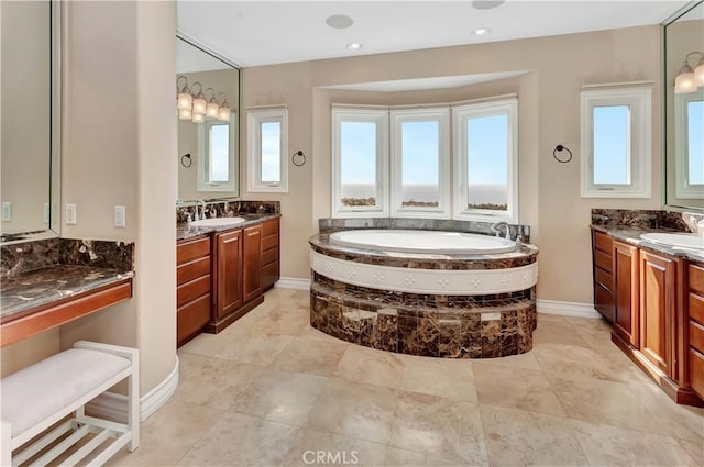 bathroom with vanity and tiled bath