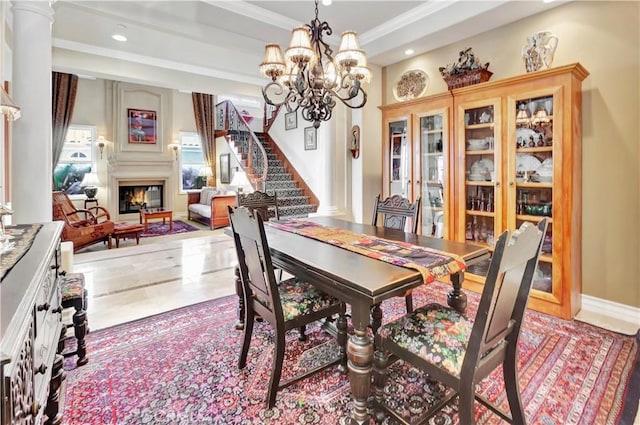 dining room featuring an inviting chandelier, ornamental molding, and ornate columns