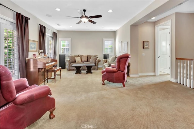 carpeted living room with ceiling fan