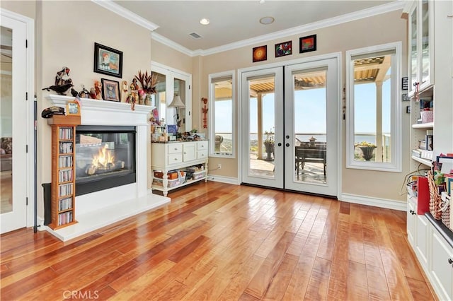 interior space with ornamental molding, light hardwood / wood-style floors, and french doors