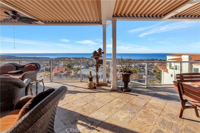 view of patio featuring ceiling fan, a balcony, and a water view