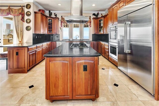 kitchen with island range hood, plenty of natural light, stainless steel appliances, and a center island