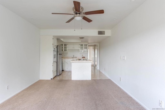 unfurnished living room with light carpet and ceiling fan