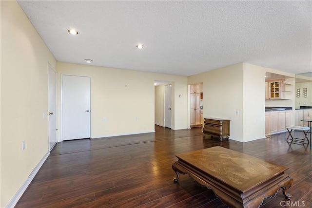 living room with dark wood-type flooring and a textured ceiling