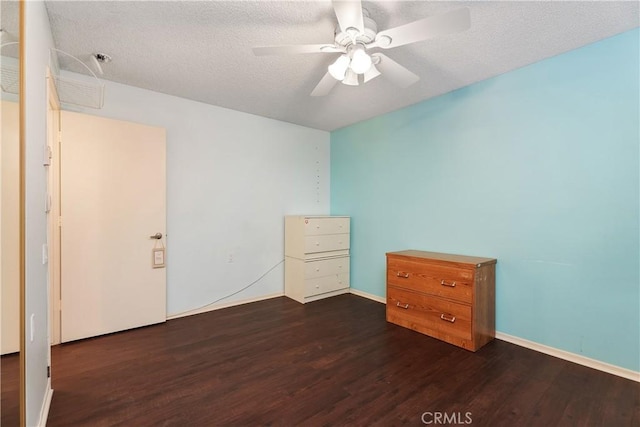 unfurnished bedroom with ceiling fan, dark hardwood / wood-style flooring, and a textured ceiling