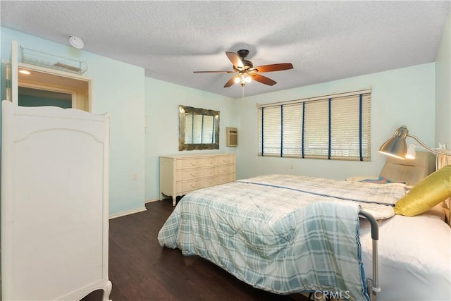 bedroom with ceiling fan, dark hardwood / wood-style floors, and a textured ceiling