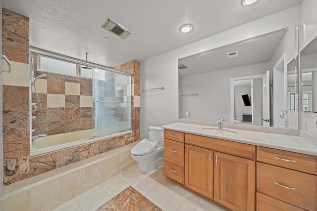 full bathroom with tile patterned floors, toilet, bath / shower combo with glass door, a textured ceiling, and vanity