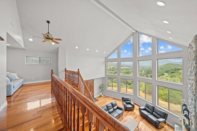 hall with beamed ceiling, high vaulted ceiling, and light hardwood / wood-style flooring