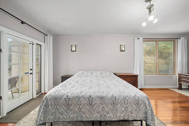 bedroom with access to exterior and hardwood / wood-style flooring