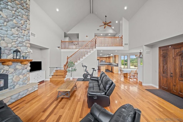 living room featuring beamed ceiling, ceiling fan, high vaulted ceiling, and light wood-type flooring