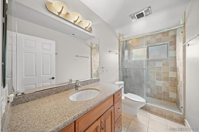 bathroom featuring vanity, toilet, a shower with shower door, and tile patterned flooring