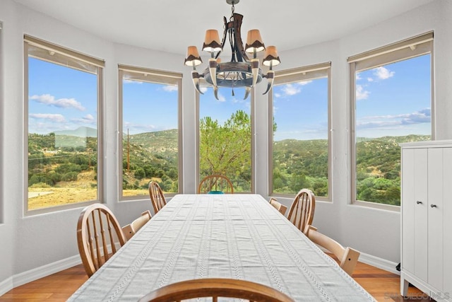 sunroom with a mountain view and a chandelier