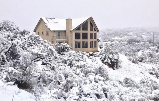 view of snow covered back of property