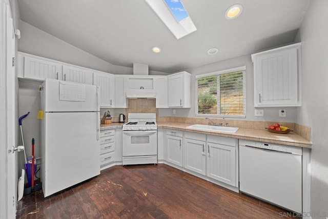 kitchen with sink, white cabinetry, dark hardwood / wood-style floors, white appliances, and vaulted ceiling with skylight