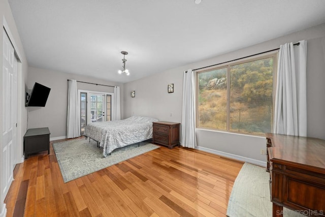 bedroom with an inviting chandelier, a closet, and light wood-type flooring