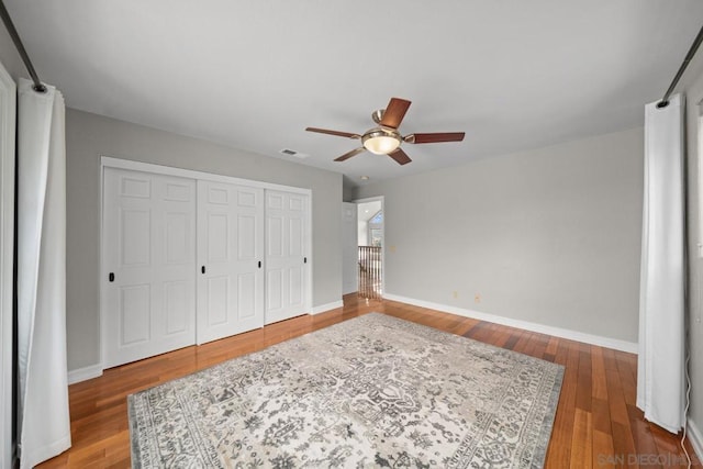 bedroom featuring hardwood / wood-style flooring, ceiling fan, and a closet