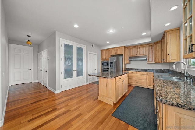 kitchen with a kitchen island, sink, dark stone countertops, stainless steel appliances, and french doors