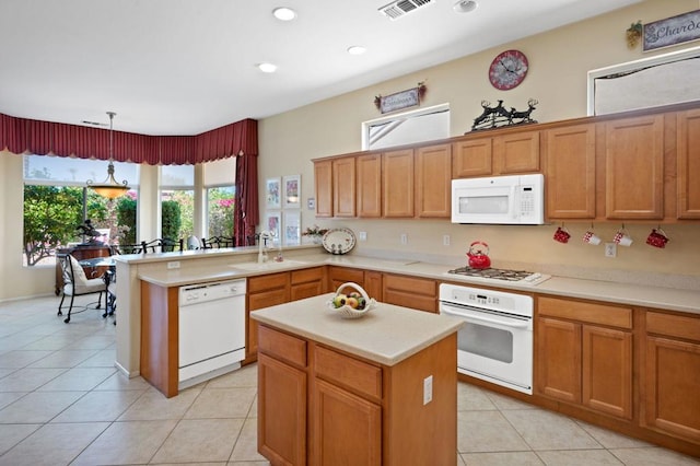 kitchen featuring light tile patterned flooring, sink, hanging light fixtures, kitchen peninsula, and white appliances