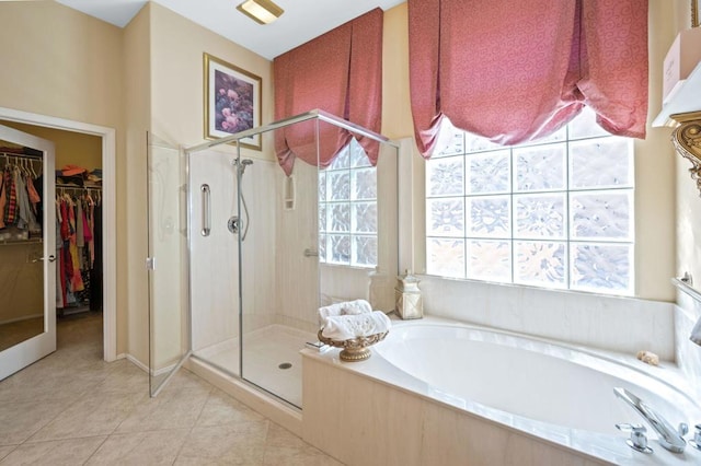 bathroom featuring plus walk in shower, tile patterned flooring, and a wealth of natural light