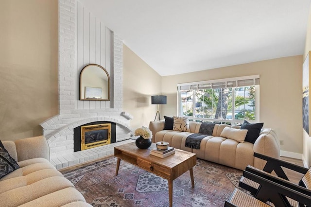 living room with lofted ceiling and a brick fireplace