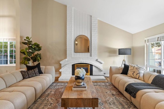 living room featuring vaulted ceiling and a fireplace