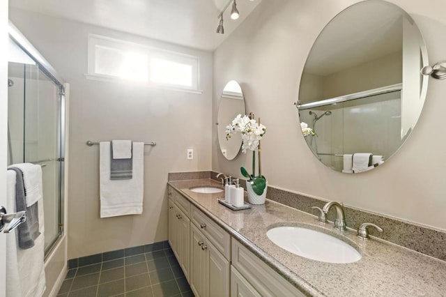 bathroom featuring tile patterned floors, vanity, and combined bath / shower with glass door