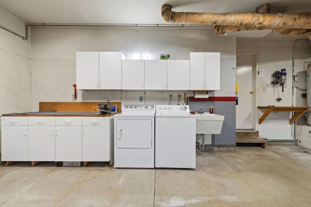 laundry area featuring a workshop area, cabinets, sink, and washer and dryer