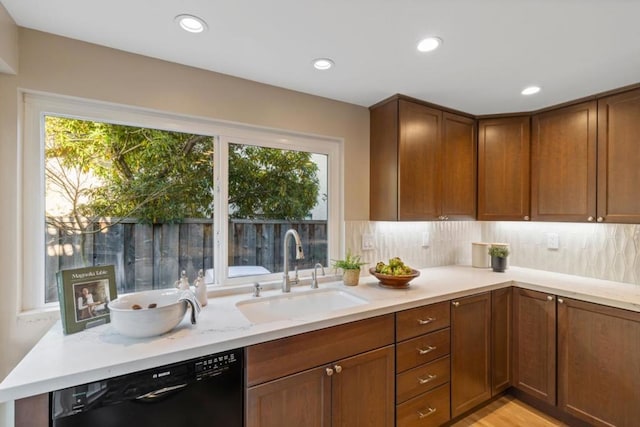 kitchen featuring dishwasher, sink, backsplash, and light hardwood / wood-style floors