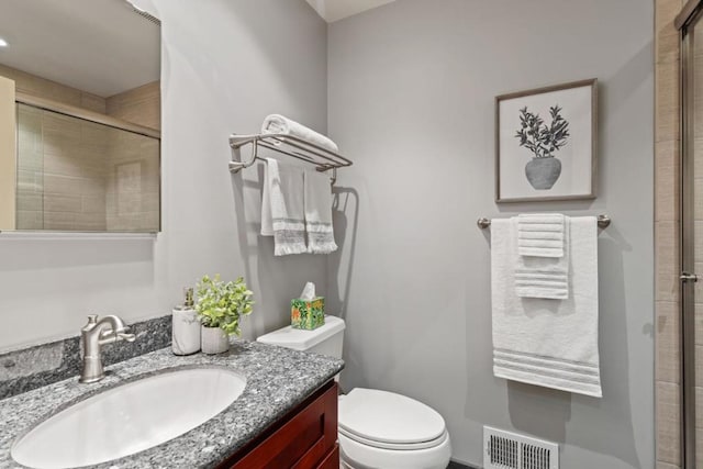 bathroom featuring an enclosed shower, vanity, and toilet