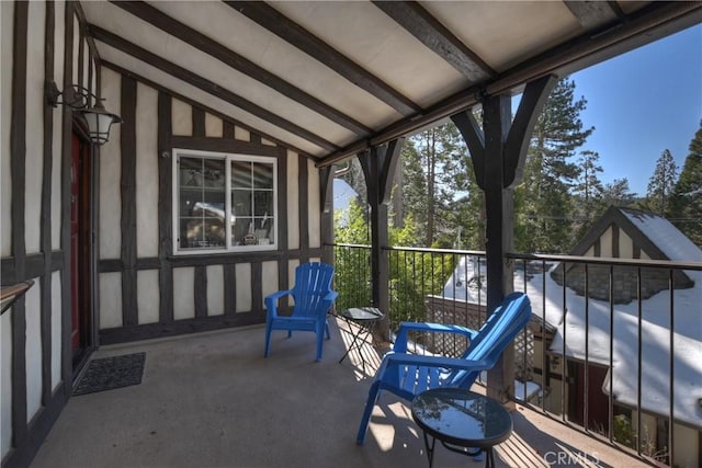 unfurnished sunroom with vaulted ceiling with beams