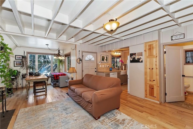 living room with sink, beam ceiling, and light hardwood / wood-style flooring