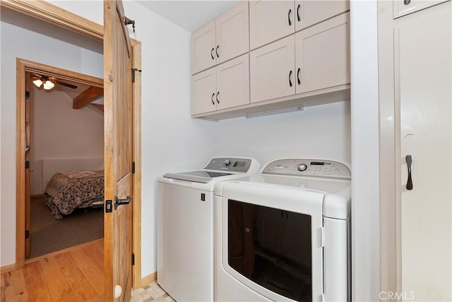 washroom featuring cabinets and washing machine and clothes dryer