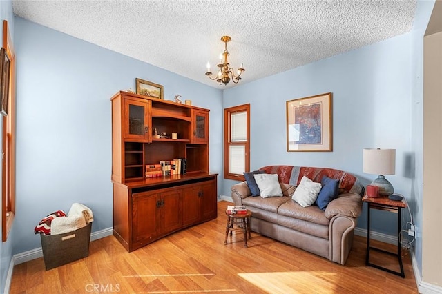 interior space featuring a notable chandelier, a textured ceiling, and light wood-type flooring