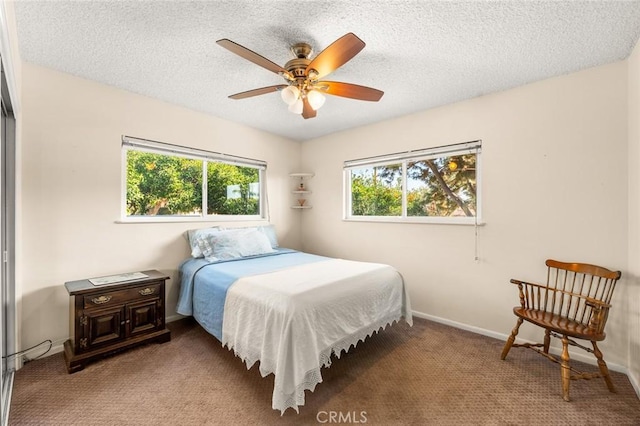 carpeted bedroom with ceiling fan and a textured ceiling