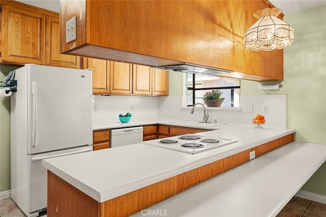 kitchen with white appliances, kitchen peninsula, sink, and light tile patterned floors