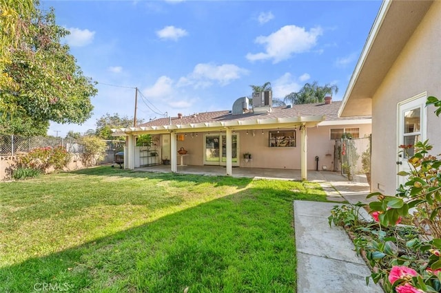 back of property with a yard, a patio area, and central AC