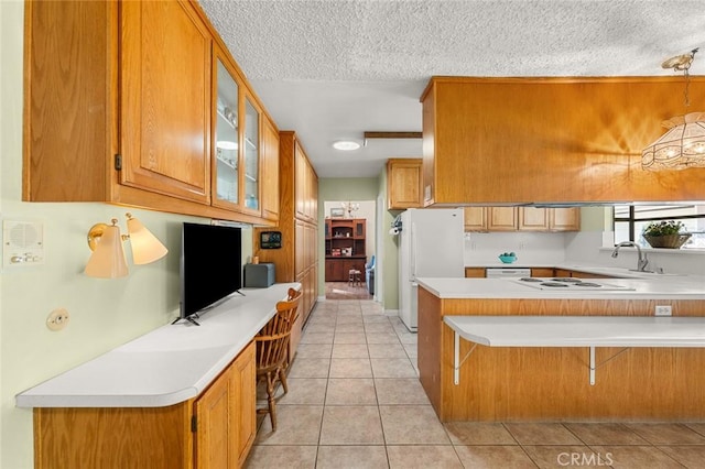 kitchen with a breakfast bar, sink, light tile patterned floors, kitchen peninsula, and white appliances