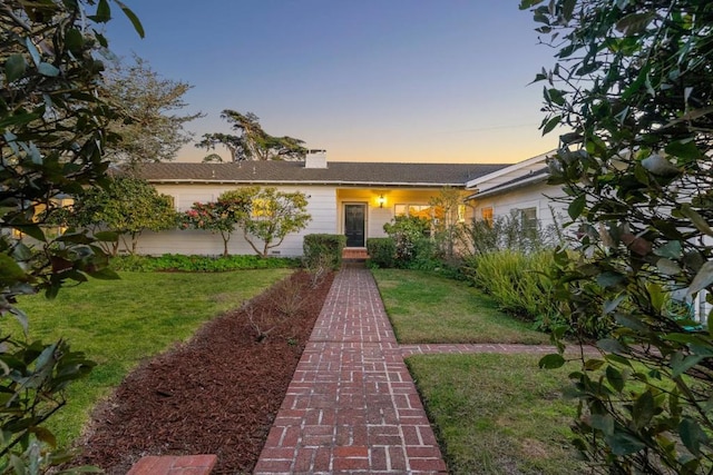 ranch-style home featuring a lawn