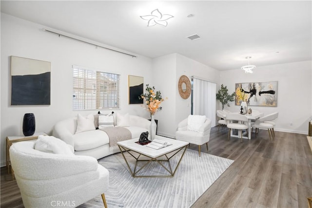 living room with hardwood / wood-style floors and a notable chandelier