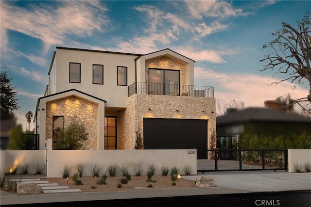 view of front of property featuring a garage and a balcony