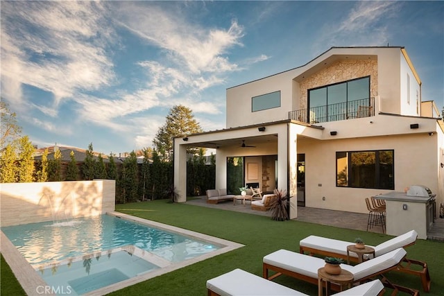 rear view of house featuring ceiling fan, a patio area, a bar, an outdoor hangout area, and a balcony