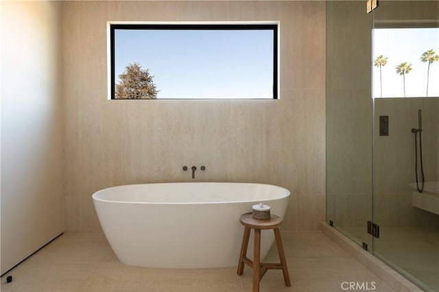 bathroom featuring tile patterned flooring and shower with separate bathtub