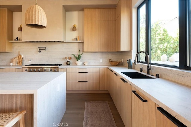 kitchen with pendant lighting, sink, decorative backsplash, and light brown cabinetry