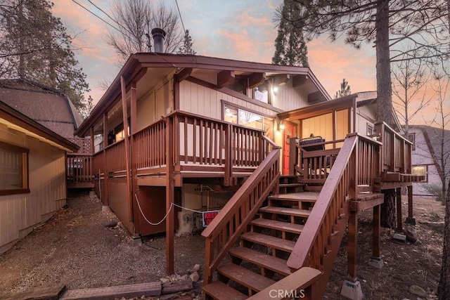 back house at dusk with a wooden deck