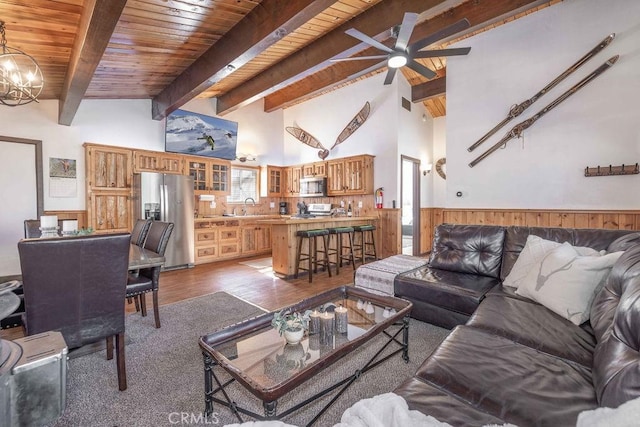 living room with sink, wood-type flooring, wooden ceiling, beam ceiling, and ceiling fan with notable chandelier